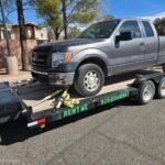 Gray Ford F-150 truck on a black trailer with "RENT ME 928 224 8997" text