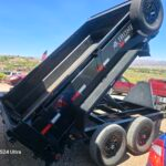 Black dump trailer with "IRONE" logo, tilted up, with red and blue cars in background.